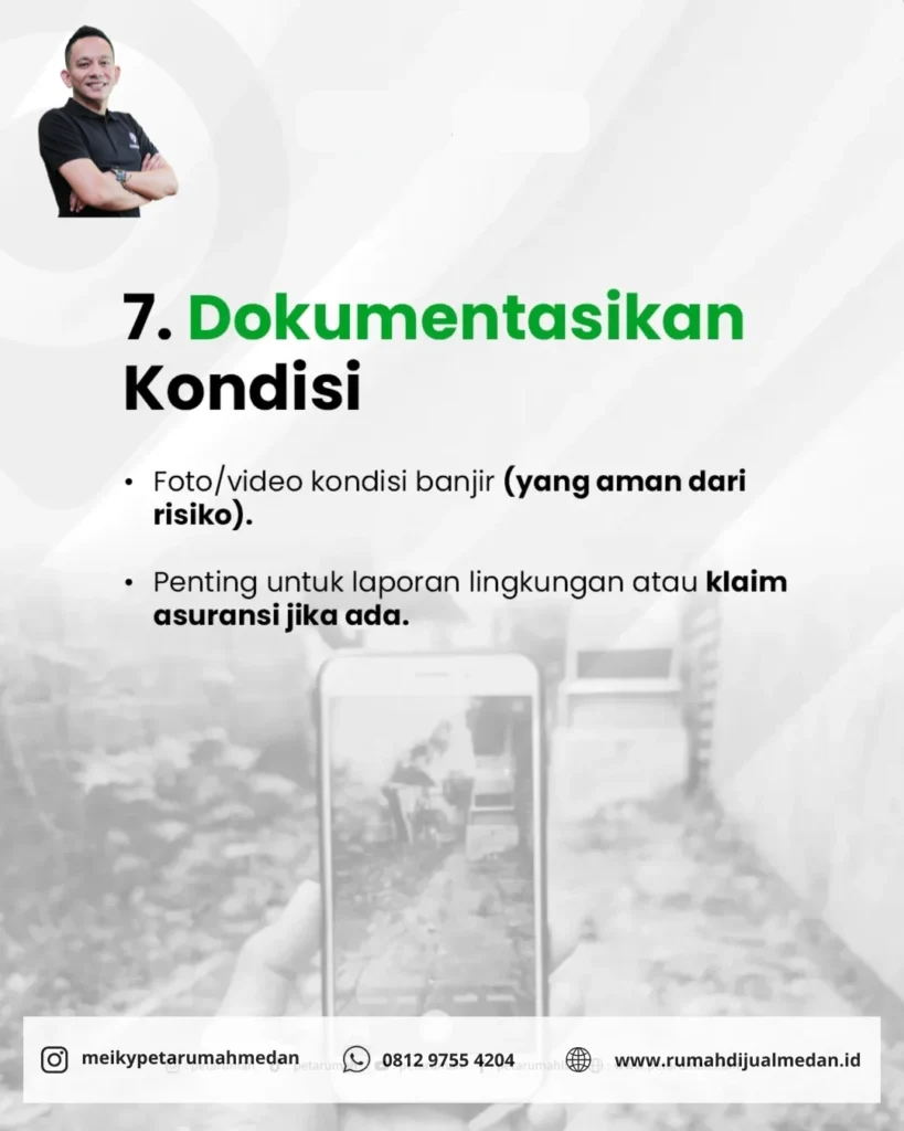 Seseorang memotret kondisi rumah yang rusak akibat banjir menggunakan HP.